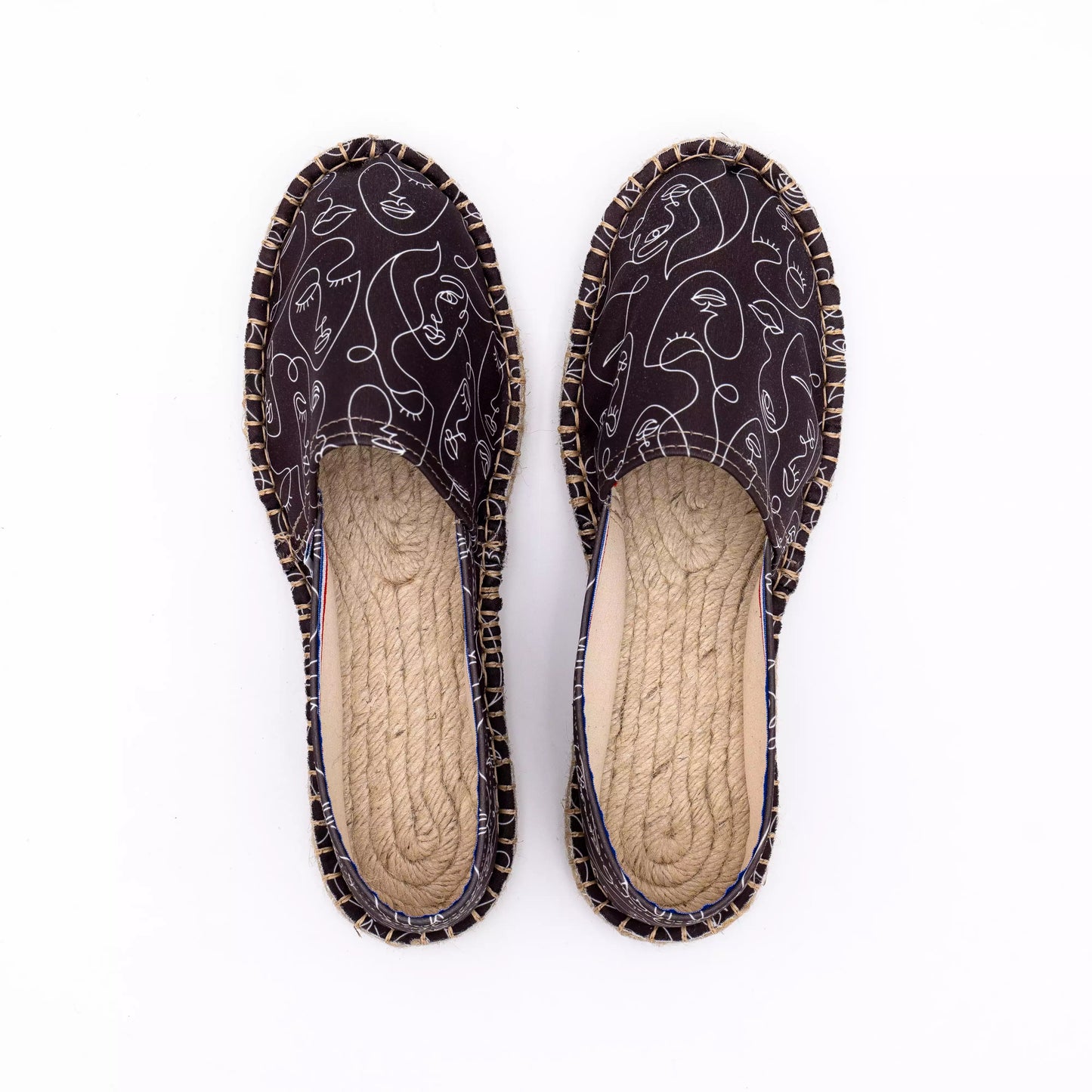 Vue de haut de l'espadrille noire avec des visages blancs